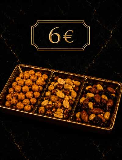 Edle Snackmischung mit Nüssen und Knabbereien in goldener Servierschale auf dunklem Hintergrund in der Lion Lounge Bar Offenbach